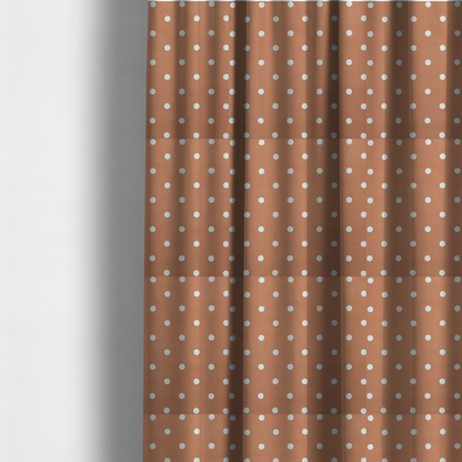 The fabric used to create these made to-measure curtains is a terracotta or warm brown fabric pattern featuring evenly spaced white polka dots arranged in horizontal and vertical rows.