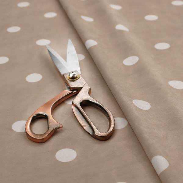 A taupe or warm grey-brown fabric pattern featuring evenly spaced white polka dots arranged in horizontal and vertical rows.