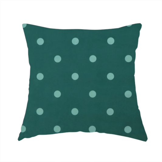 The fabric used to create this handmade cushion is a dark teal or blue-green fabric pattern featuring evenly spaced pale green or off-white polka dots arranged in horizontal and vertical rows.