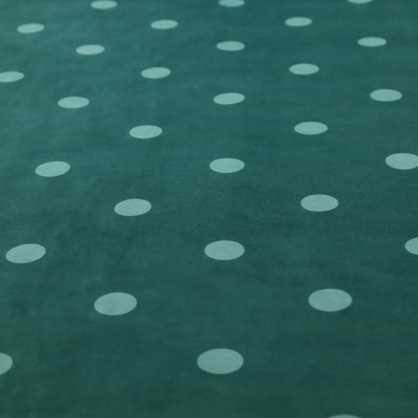 A dark teal or blue-green fabric pattern featuring evenly spaced pale green or off-white polka dots arranged in horizontal and vertical rows.