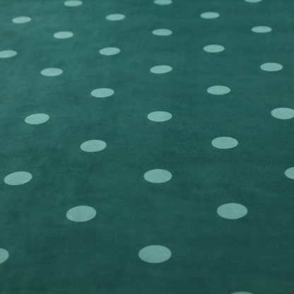 A dark teal or blue-green fabric pattern featuring evenly spaced pale green or off-white polka dots arranged in horizontal and vertical rows.