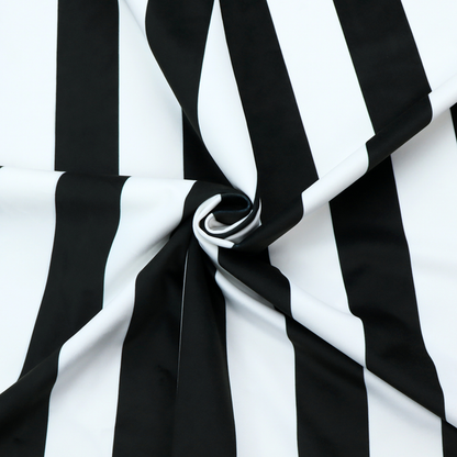 A vertically striped fabric pattern featuring alternating bands of black and white.