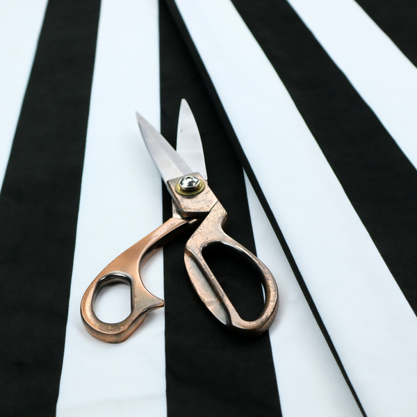 A vertically striped fabric pattern featuring alternating bands of black and white.
