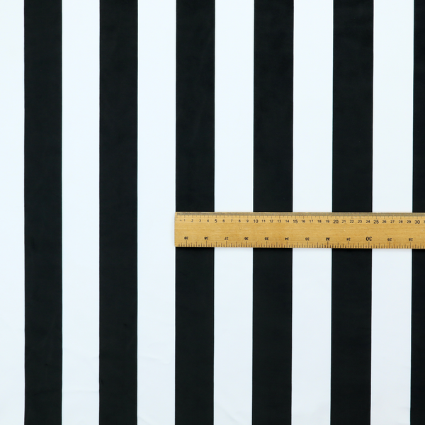 A vertically striped fabric pattern featuring alternating bands of black and white.