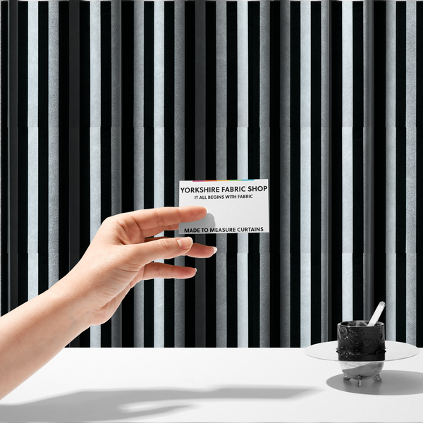 The fabric used to create these made-to-measure curtains is a vertically striped fabric pattern featuring alternating bands of black and white.