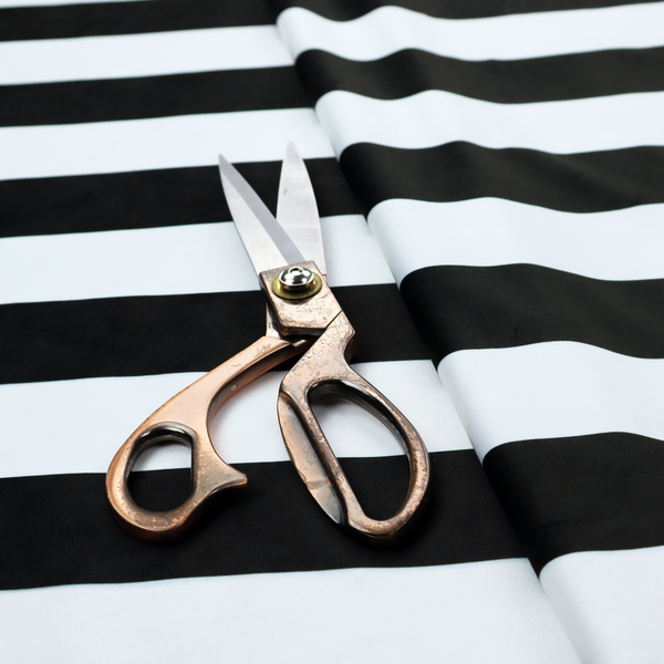 A horizontally striped fabric pattern featuring alternating bands of dark black and white.   