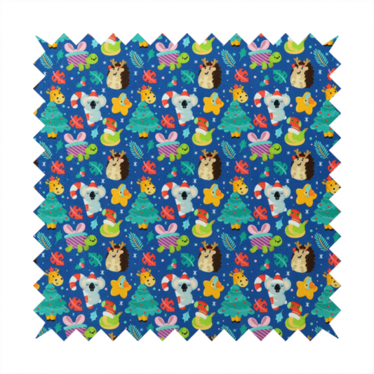 A repeating festive Christmas print on a royal blue background featuring cute cartoon holiday characters, including koalas wearing Santa hats, hedgehogs with antlers, giraffes, Christmas trees, wrapped presents, and stars.   