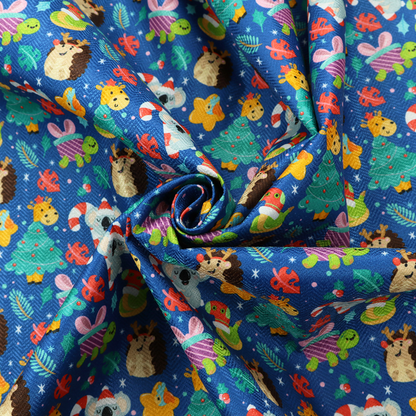 A repeating festive Christmas print on a royal blue background featuring cute cartoon holiday characters, including koalas wearing Santa hats, hedgehogs with antlers, giraffes, Christmas trees, wrapped presents, and stars.   