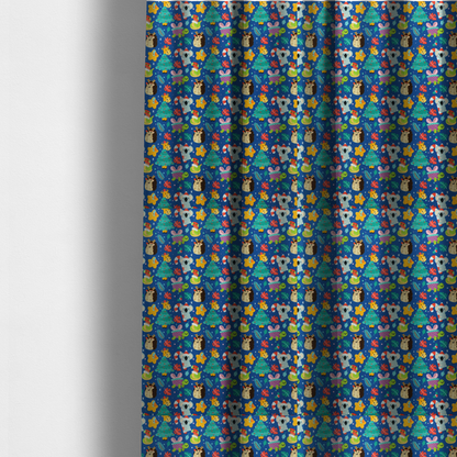 The fabric used to create these made-to-measure curtains is a repeating festive Christmas print on a royal blue background featuring cute cartoon holiday characters, including koalas wearing Santa hats, hedgehogs with antlers, giraffes, Christmas trees, wrapped presents, and stars.   