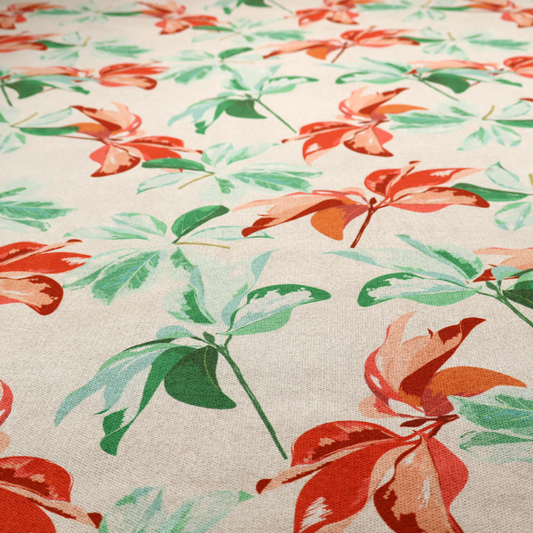 A botanical upholstery fabric on a neutral cream background featuring a repeating painterly pattern of leafy branches in shades of vibrant orange, coral, deep green, and pale mint-green.   